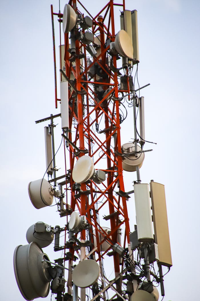 journey A close-up of a tall telecommunication tower with antennas and equipment against the sky.